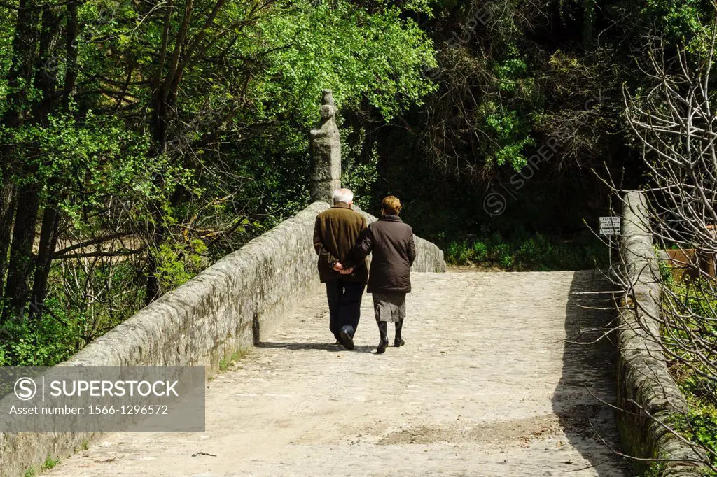 elderly couple crossing the bridge Cuacos, XVIII century, Garganta De La Olla, Tietar Valley, La Vera, Caceres, Extremadura, Spain, europe.