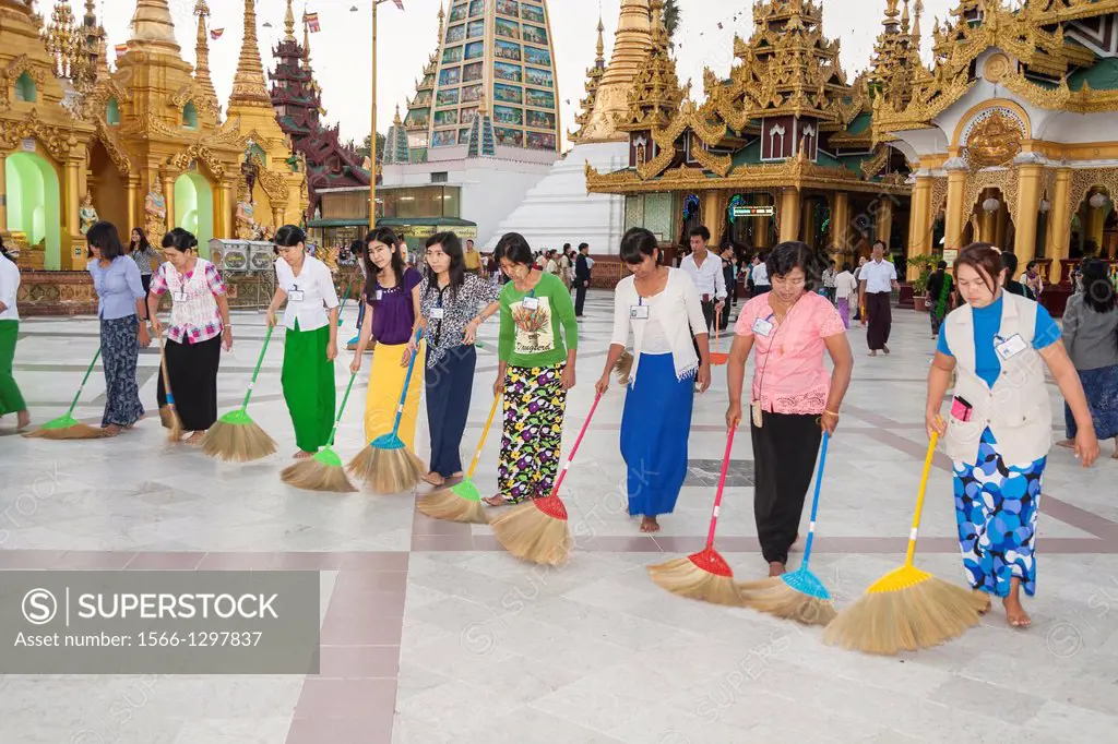Women sweeping tiled floor at Shwedagon Pagoda, Yangon, (Rangoon), Myanmar, (Burma).
