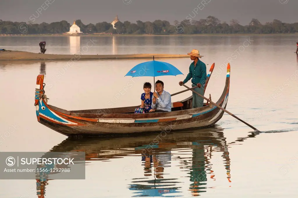 Boatman and tourists in a boat on Taungthaman Lake, Amarapura, Mandalay, Myanmar, (Burma).