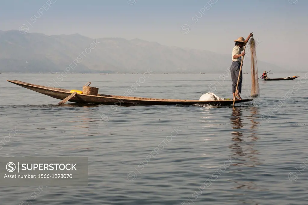 Intha fisherman fishing in a traditional fishing boat, Inle Lake, Nyaung Shwe, Shan State, Myanmar, (Burma).
