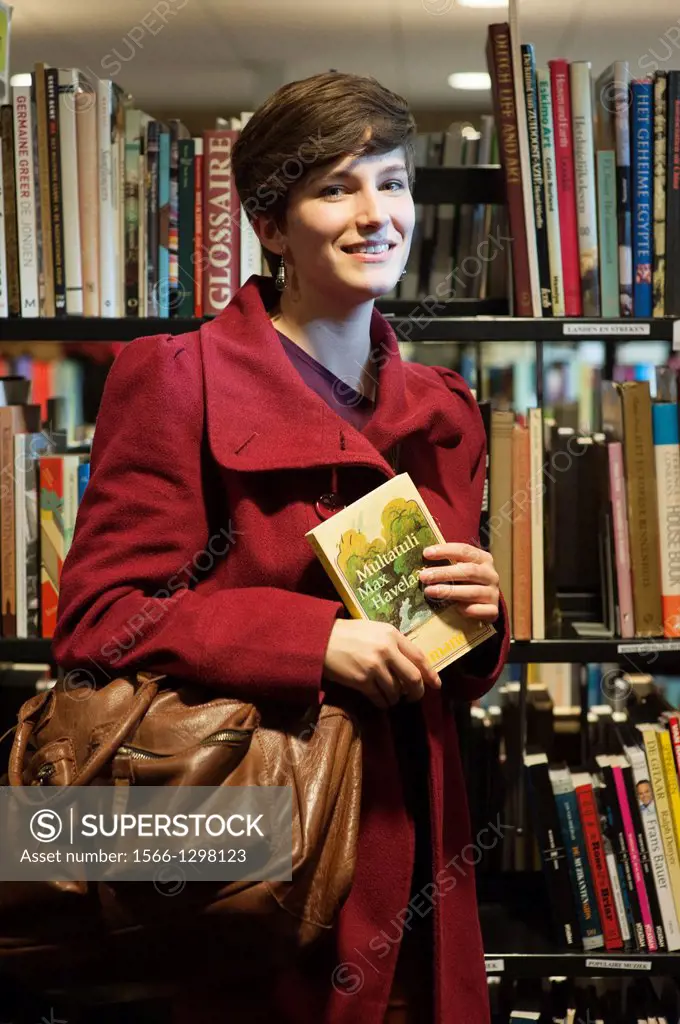 Tilburg, Netherlands. Portrait of a young brunette Philosophy student at Tilburg University, just buying a book at a second hand book store.
