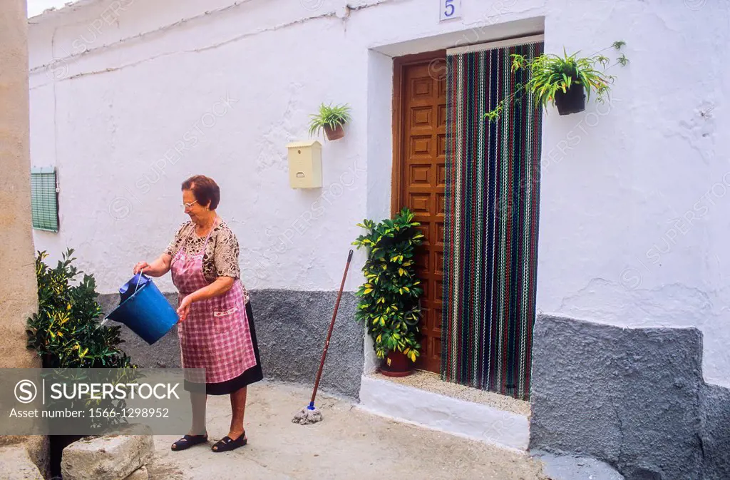 woman watering plants, Ohanes.Alpujarras, Almeria province, Andalucia, Spain.