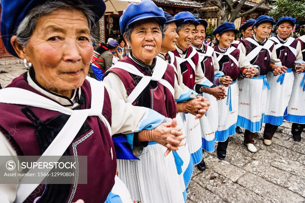 Naxi women in traditional costume dancing in Lijiang Old Town, Yunnan, China.
