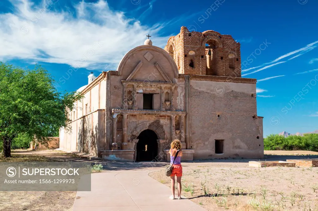 A woman visitor take a picture of the preserved Spanish mission at Tumacacori, Arizona.