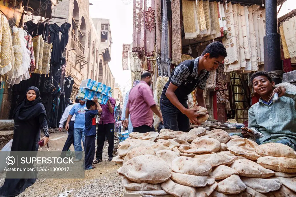 Bazaar street scene with child selling bread. Islamic Cairo, Egypt.