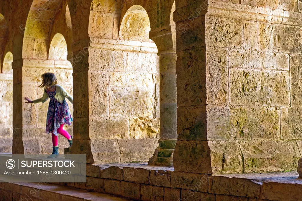 Europe, France, Var, Le Thoronet, Cistercian Abbey. Young girl playing in the The cloister.