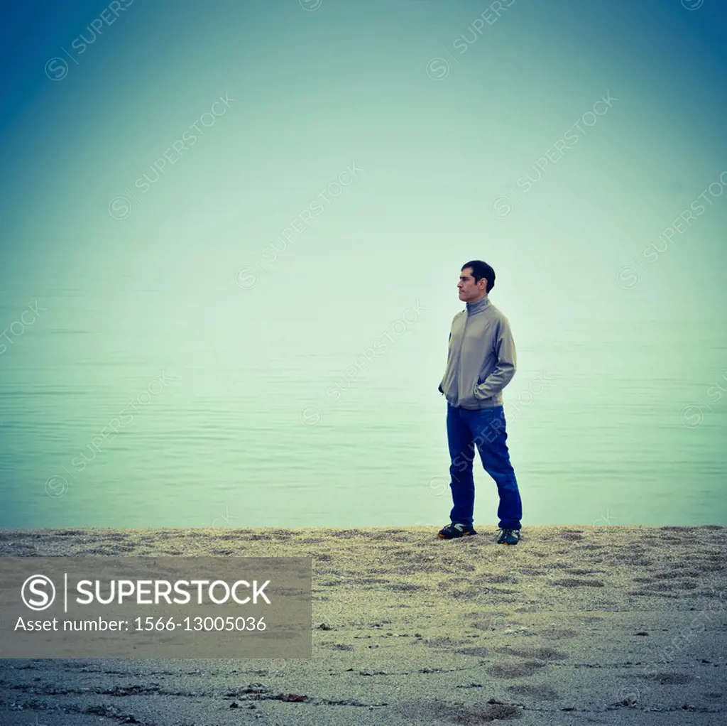 Lone man on the beach watching the sea.