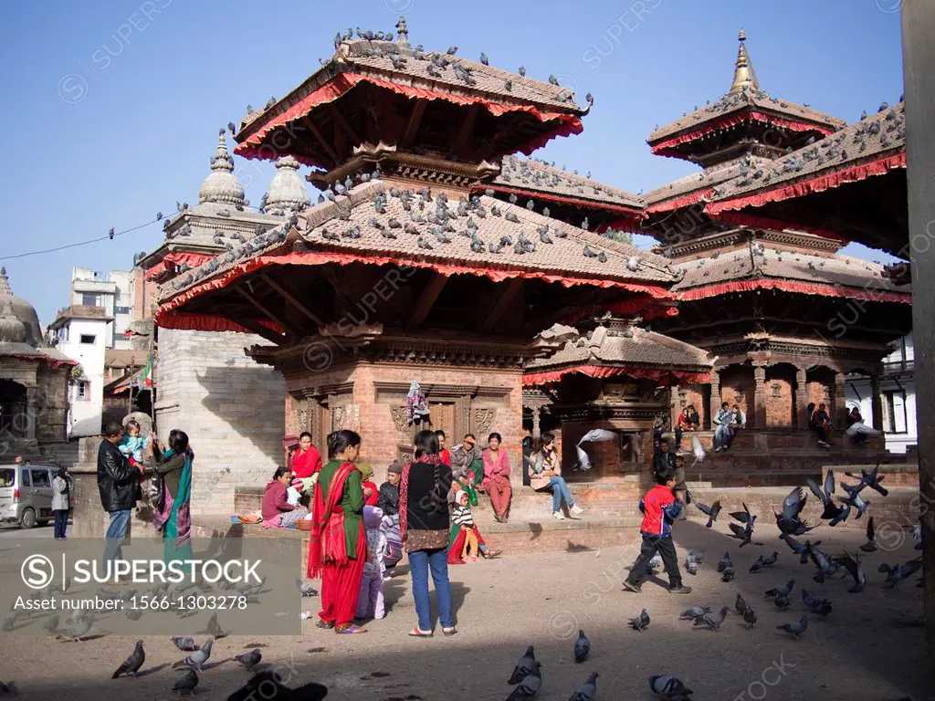 Piegones and people cover a square surrounding several temples in Kathmandu, Nepal.