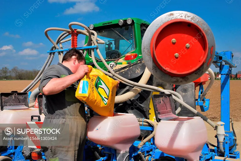 Farmer sowing machine filled with fertilizer.