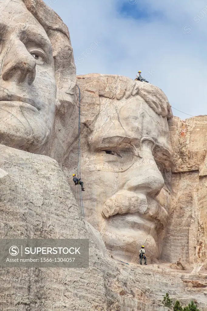Park service employees rappel down the face of Mount Rushmore while conducting an inspection, Mount Rushmore National Monument, South Dakota.