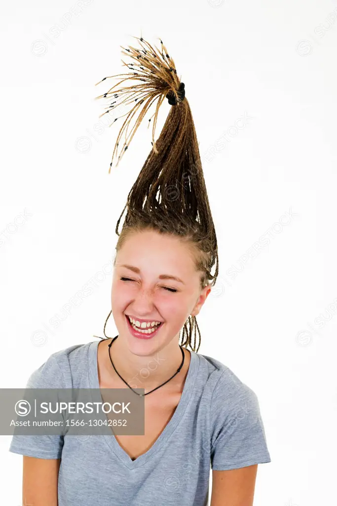 Very cheerful blonde girl laughs vigorously her tresses are raised vertically on her head.