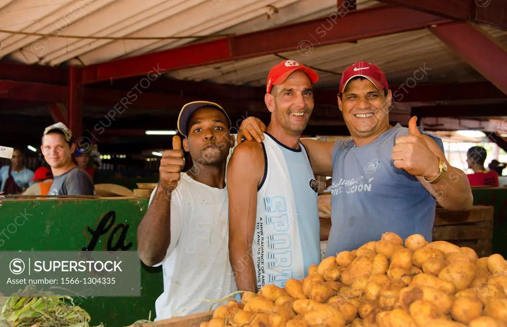 Havana Cuba three local men selling potatos at market in city center.