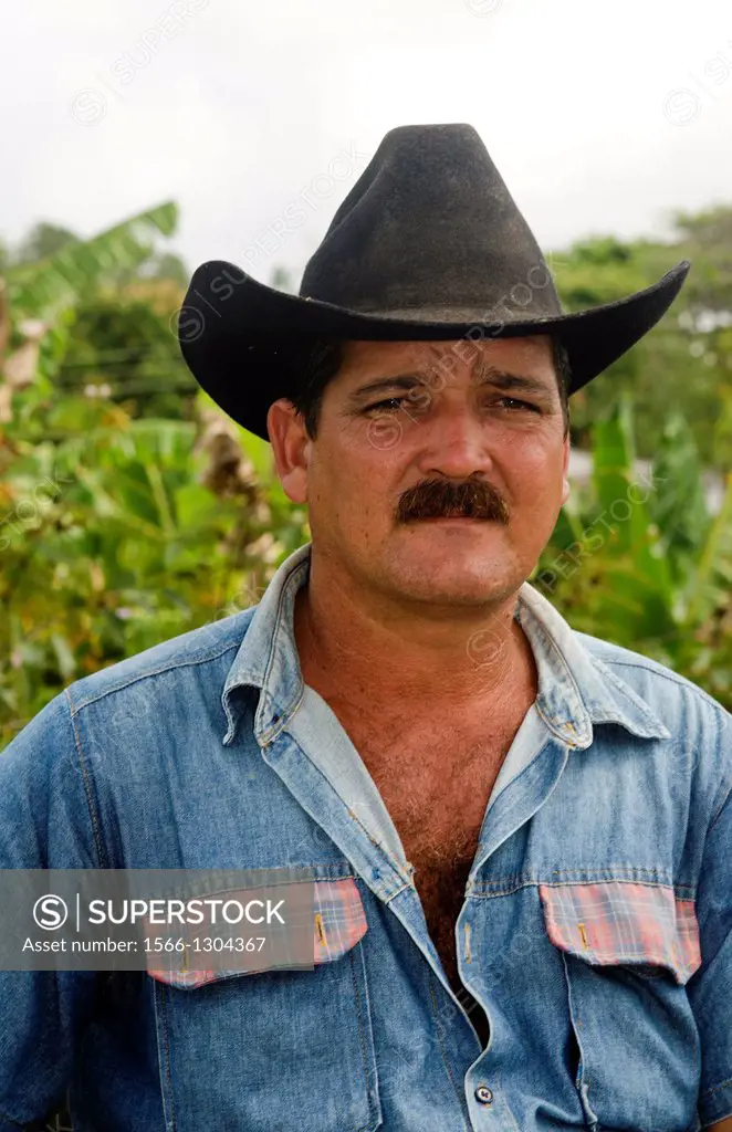 Trinidad Cuba real cowboy on horse riding on road portrait from ranch.