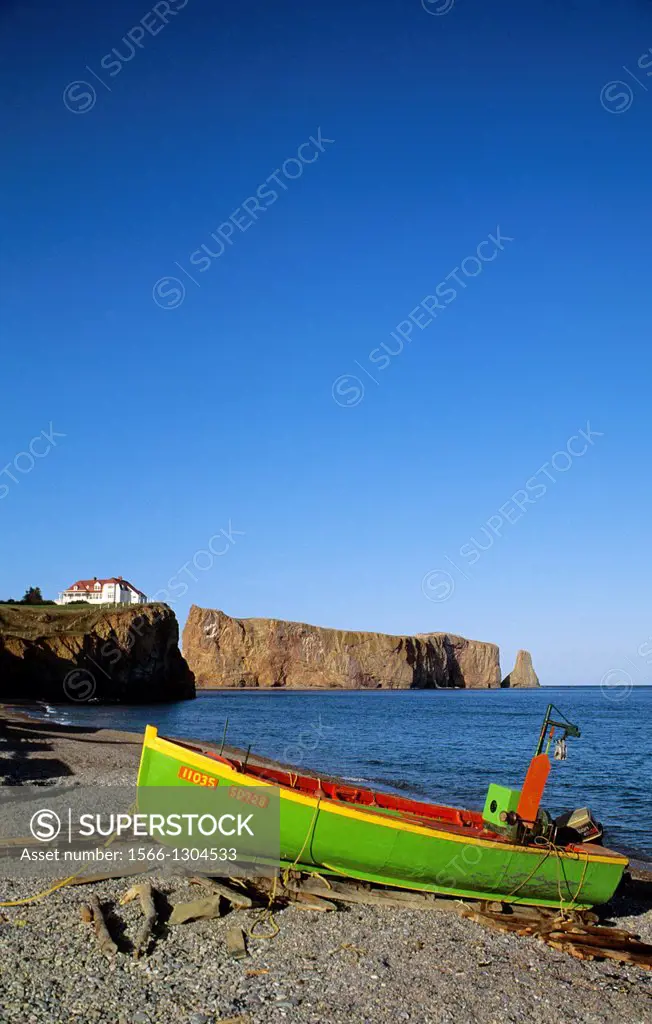 CANADA, QUEBEC, GASPE, PERCE, FISHING BOAT ON BEACH WITH PERCE ROCK IN BACKGROUND.
