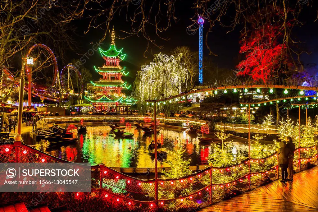 Denmark, Sjelland, Copenhagen . Christmas in Tivoli Gardens, Dragon Boat lake, the Pagoda and the bridge over Tivoli Lake with Christmas decorations