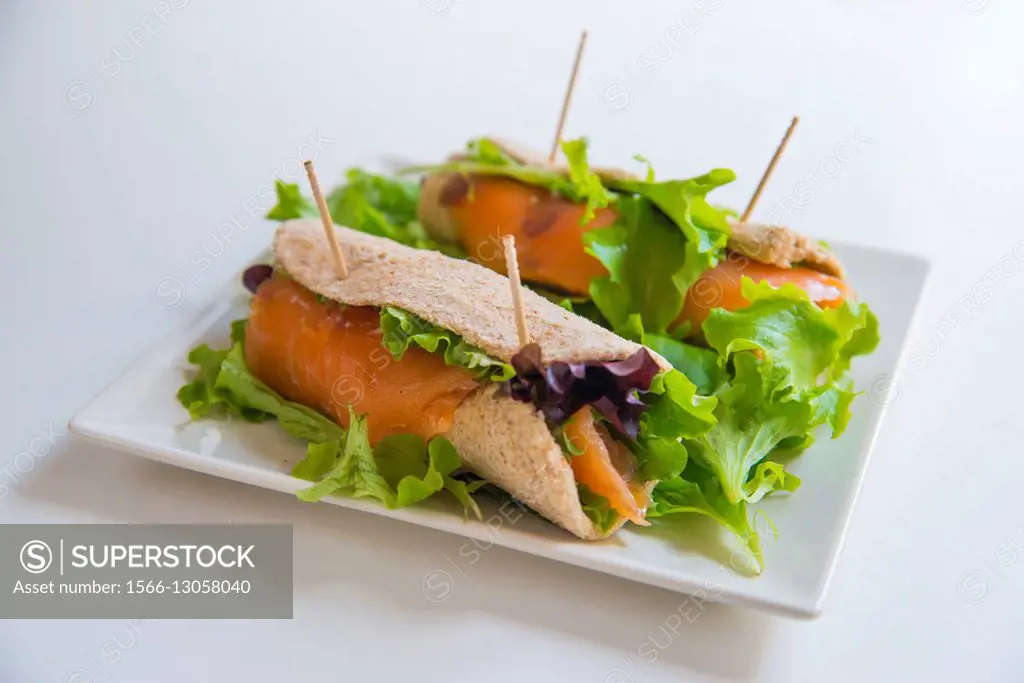 Smoked salmon with lettuce in rolled bread. Close view.