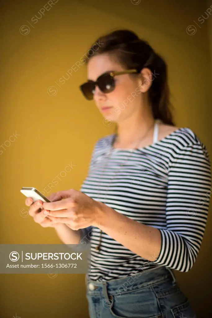 young woman, 21, using a phone.