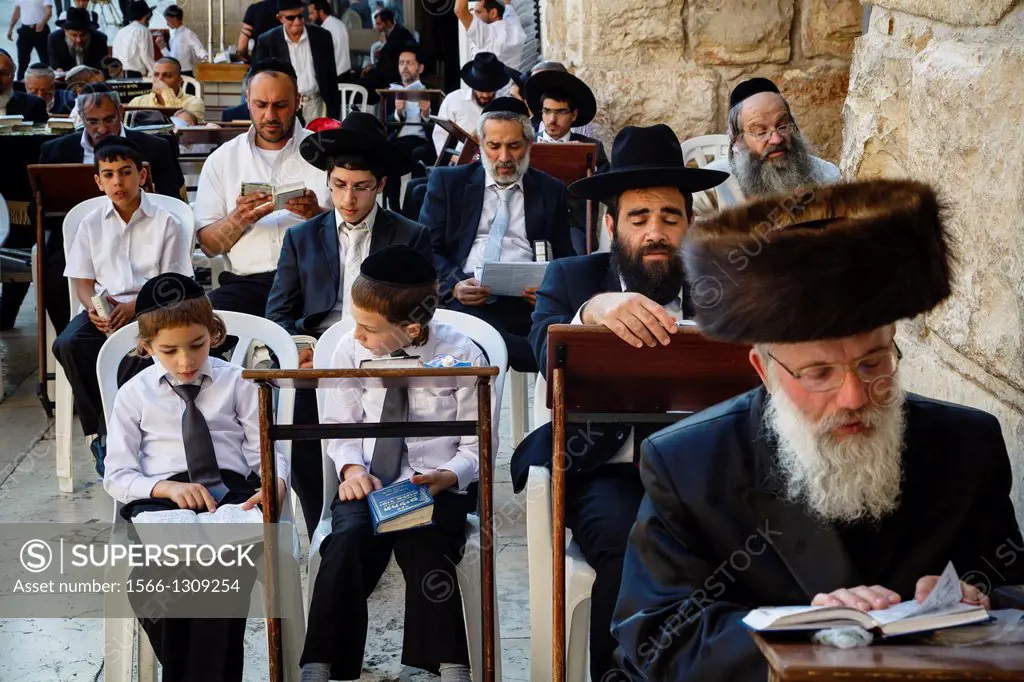 Orthodox jewish people praying at a synagogue by the western wall wall (Wailing wall) in the old city, Jerusalem, Israel.