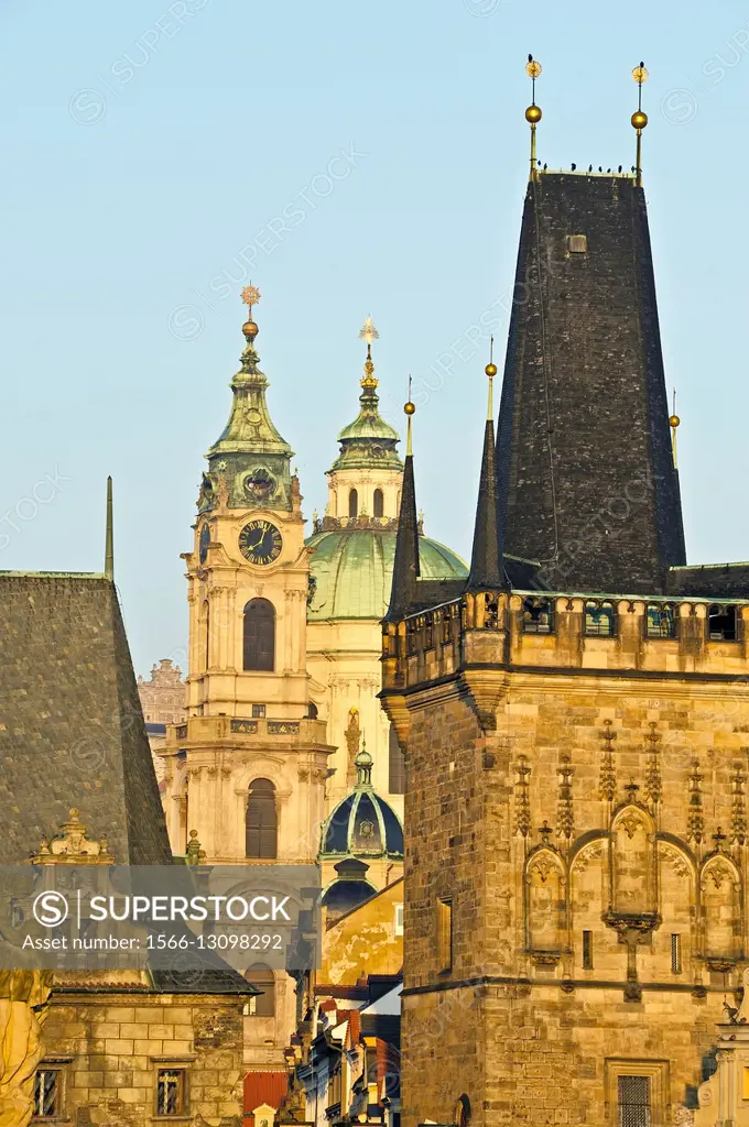 Tower in the foreground on the Charles Bridge, in the background the St. Nicolas church, Prague, Czech Republic, Europe.