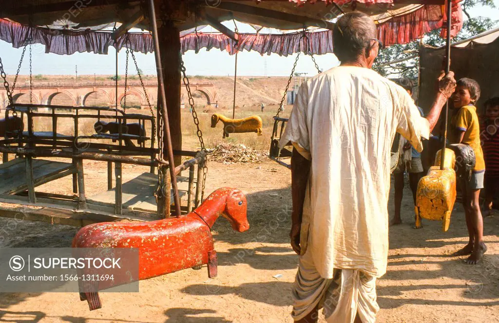 old fashioned merry-go-round with wooden animal at fair at Sonpur, India