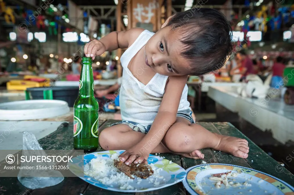 Boy having lunch on a table, Carbon market, Visayas, Philippines, South East Asia.