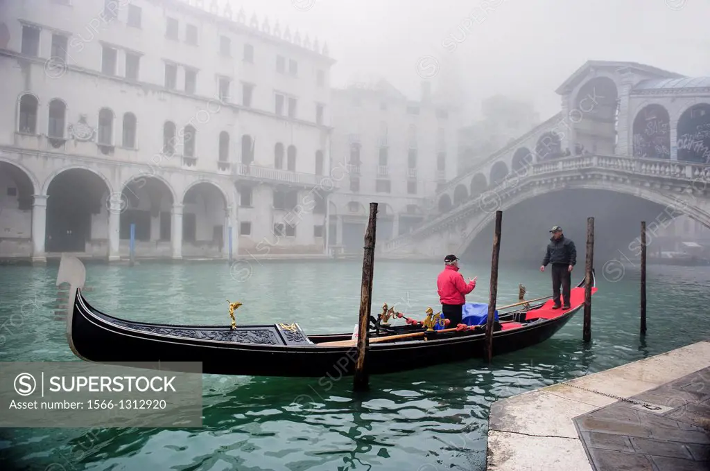 A Gondola sailing along the Grand canal of Venice covered with thick fog, Italy.