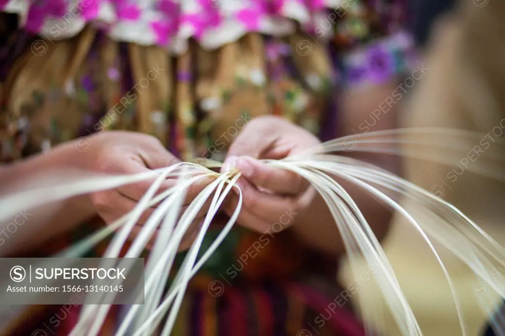 Guatemala, Quetzaltenango, close up of weavers hands making straw mat
