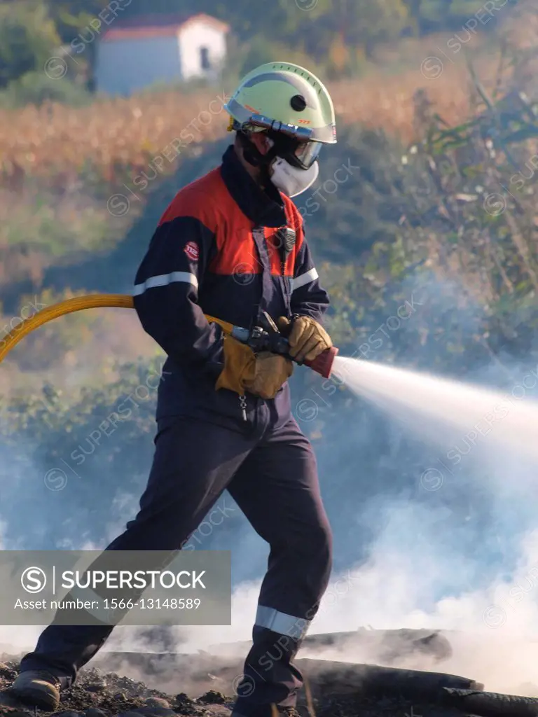 firefighter fighting against fire with a hose.