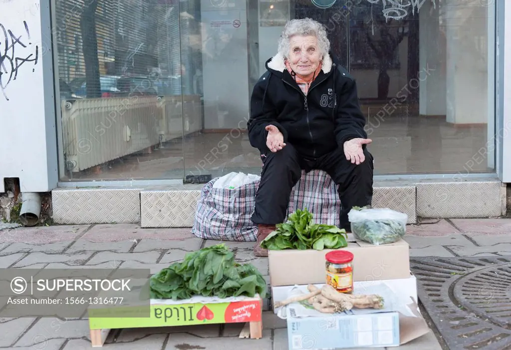 Down town, Sofia, Bulgaria. Elder Bulgarian woman offering some groceries from het kitchen garden.
