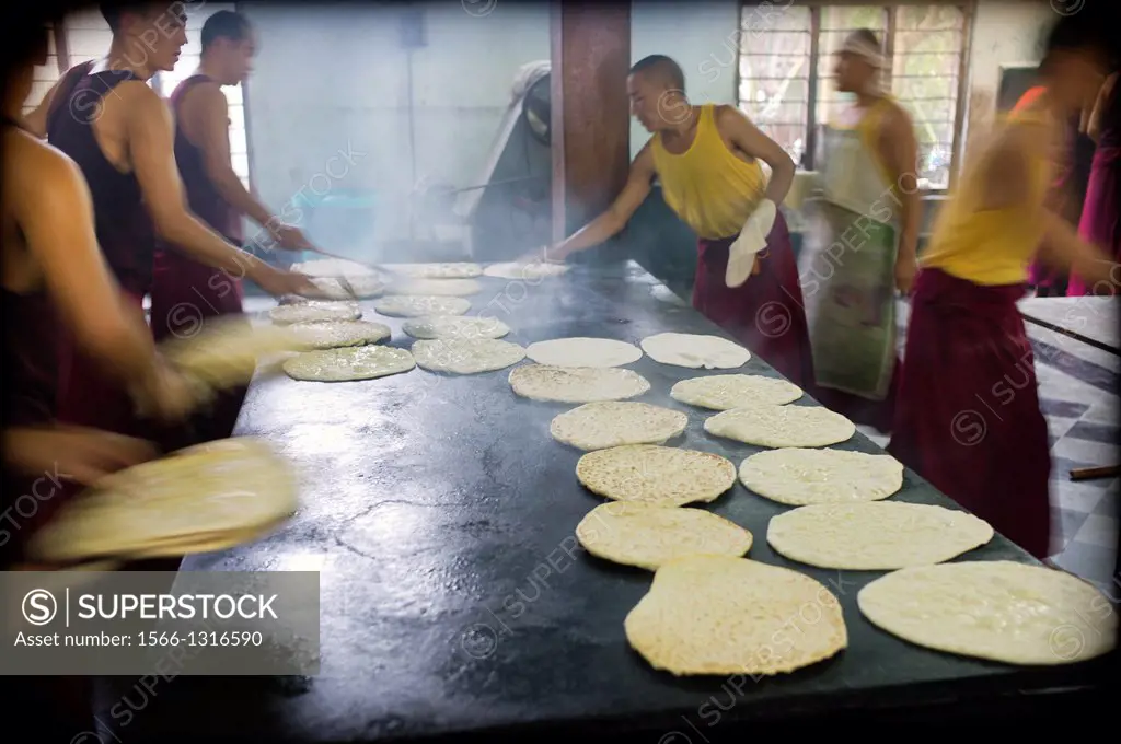 Buddhist monks in the kitchen and bakery making bread at Tibetan monastery Gaden Shartse, Mundgod, Karnataka, India, Asia