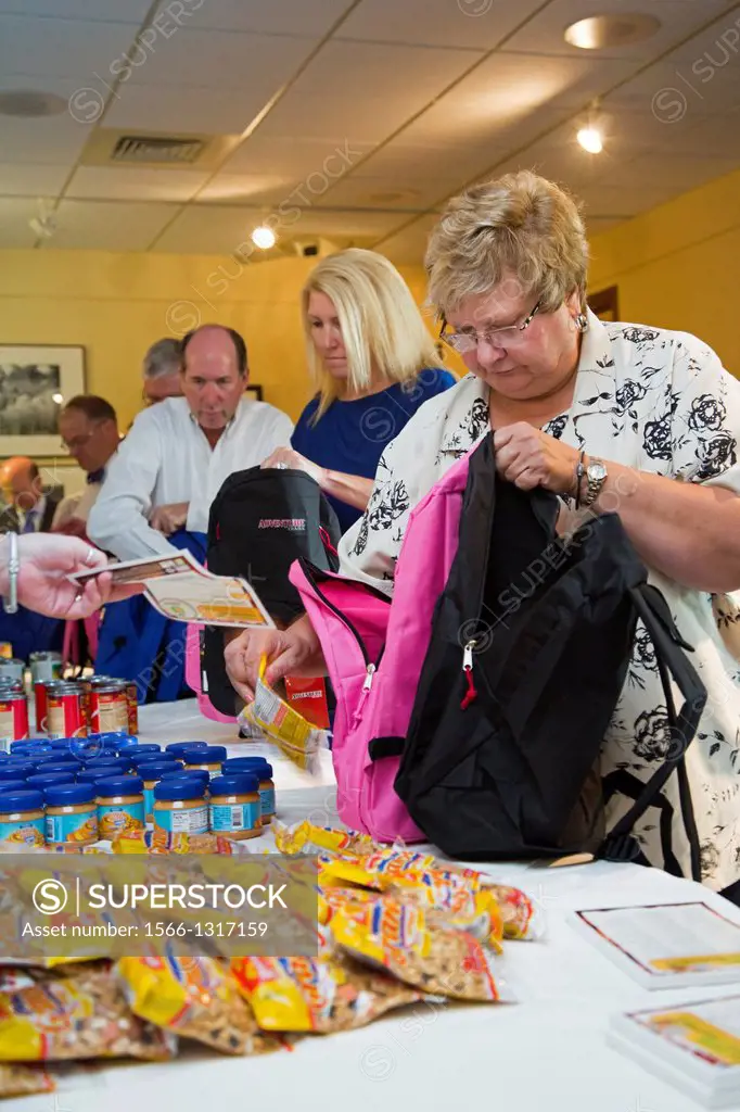 Detroit, Michigan - Executives and CEOs from local corporations volunteer to fill backpacks with food for school children to be distributed as part of...