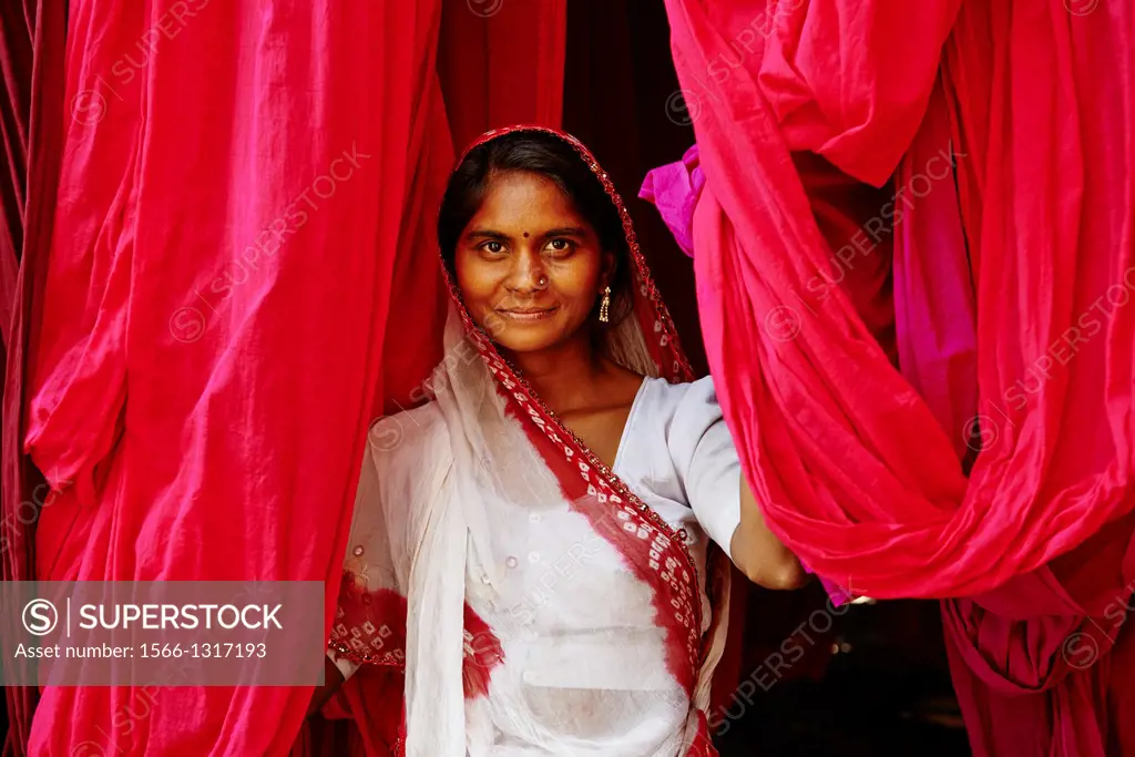 India, Rajasthan, Sari Factory, Textile are dried in the open air. Collecting of dry textile are folded by women and children. The textiles are hung t...