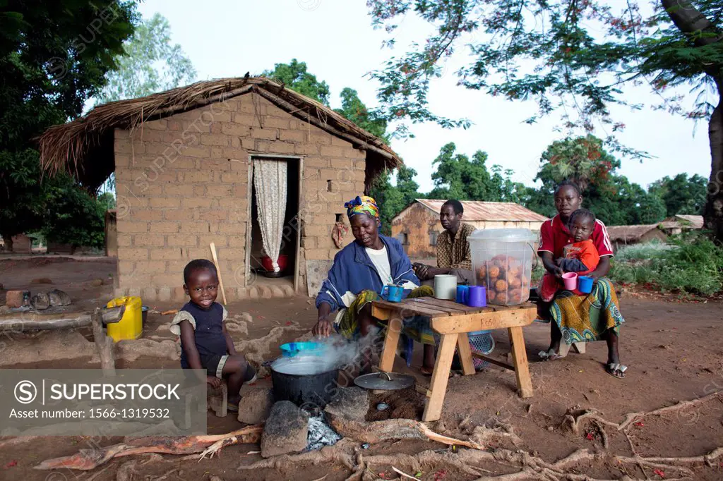 family in front of their house in central african republic.