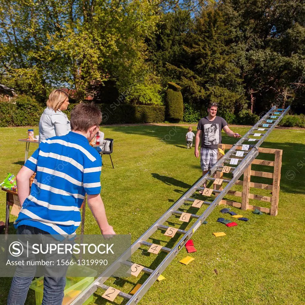 A boy playing the ladder and beanbag game at a village fete and open gardens at Sotterley Hall in Sotterley , Suffolk , England , Britain , Uk.