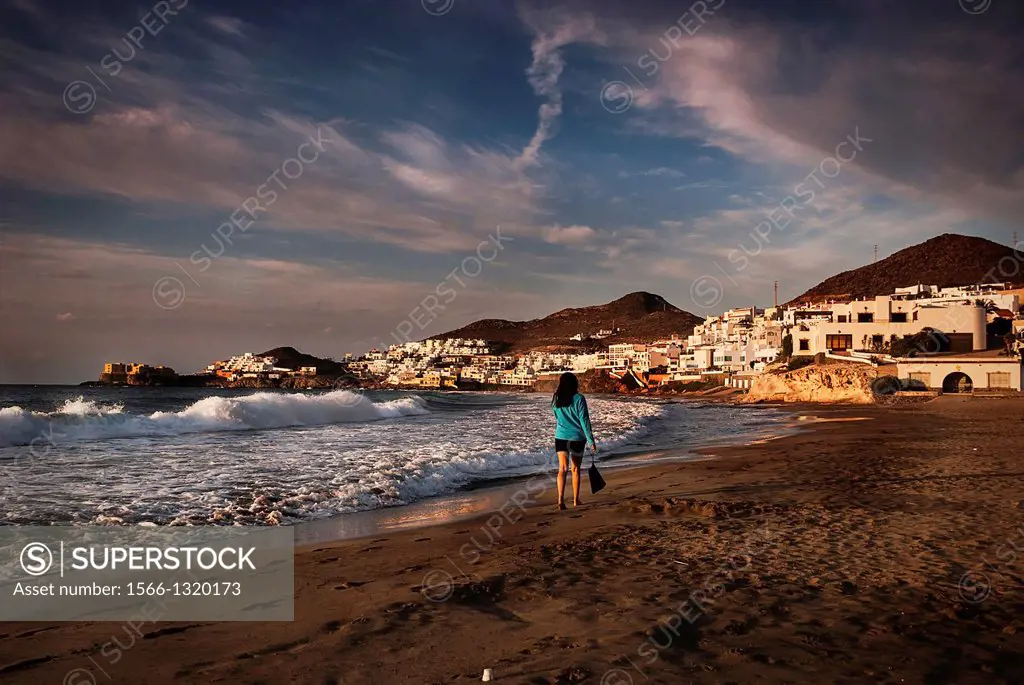 Woman walking at dawn on the beach in San José Almería.