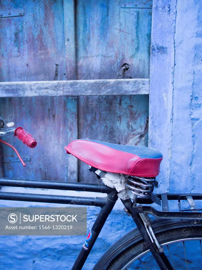 Bicycle parked in front of blue painted wall in Jodhpur, Rajasthan, India.