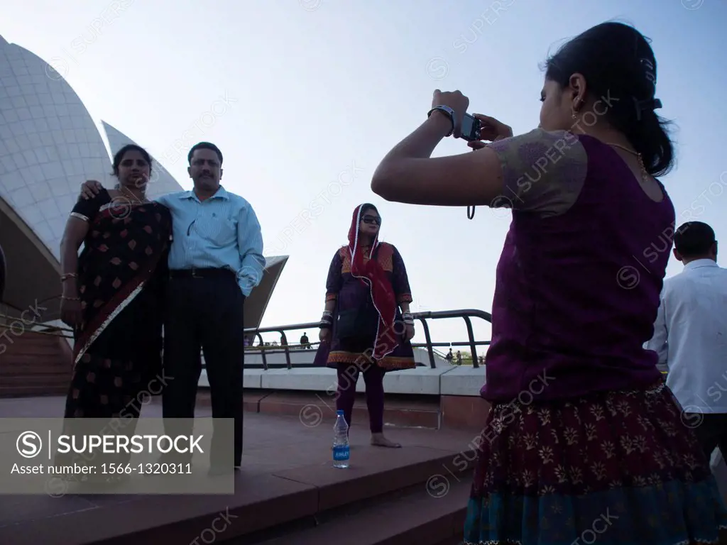 Family photographing in front of lotus temple in New Delhi, India.