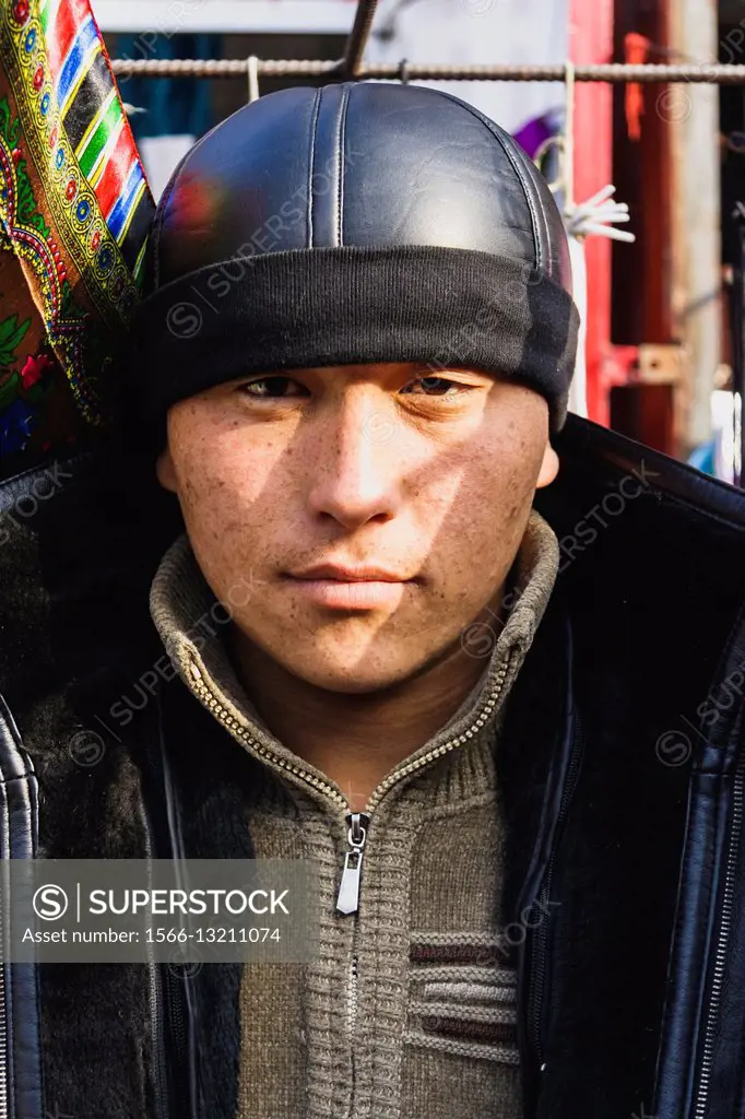 Portrait of young Kyrgyz vendor man at the big bazaar in Osh, Kyrgyzstan.