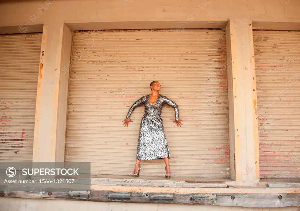 African American woman standing in front of warehouse door in urban Memphis Tennessee USA.