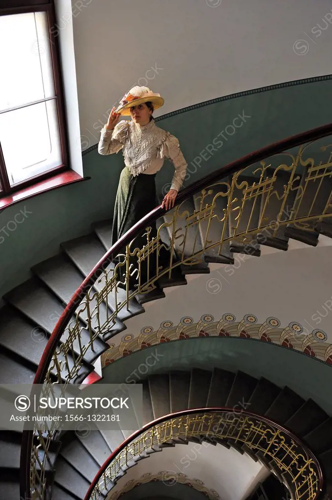 young woman in period costume in the spiral staircase of the Art Nouveau Museum which is located in the apartment where the Latvian architect Konstant...