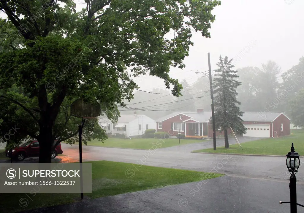 Torrential rain from a violent thunderstorm obscures the view of neighborhood houses in the Town of Vestal, New York..
