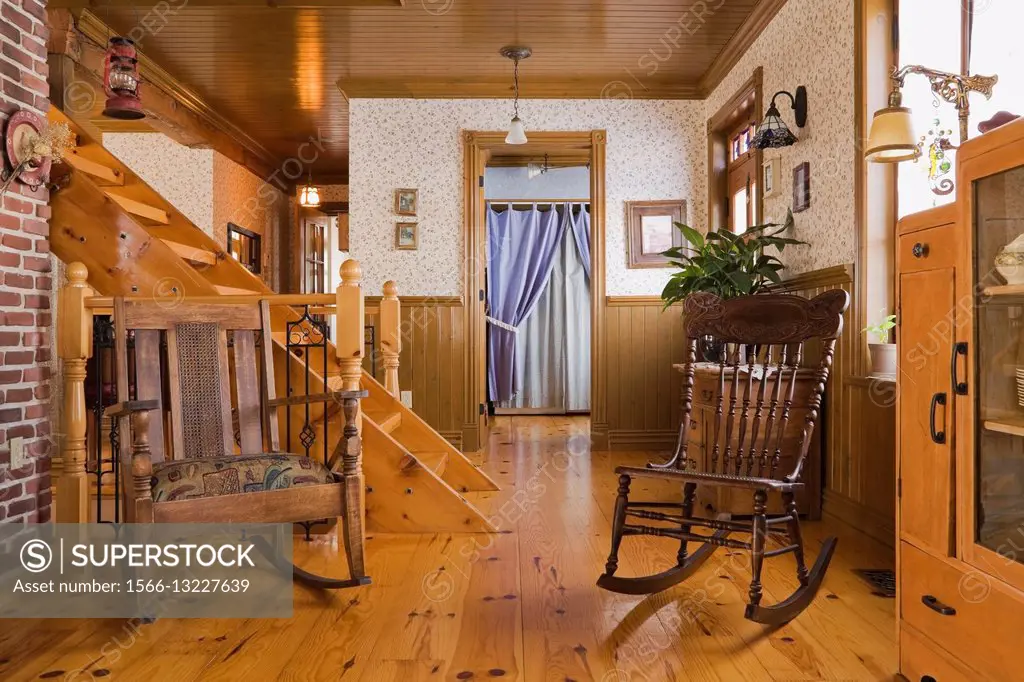 Antique wooden chairs in the living room of a Canadiana cottage style fieldstone residential home built to look old in 2002, Quebec, Canada.