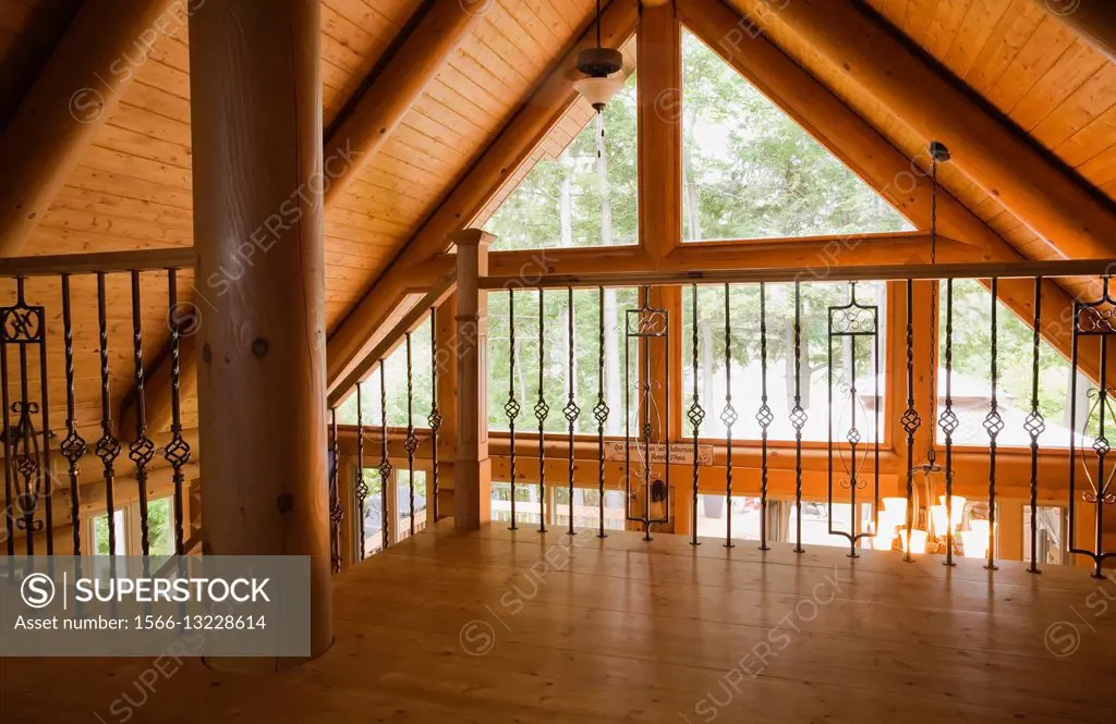 Partial view of the master bedroom on the upstairs floor inside a residential log home, Laurentians, Quebec, Canada