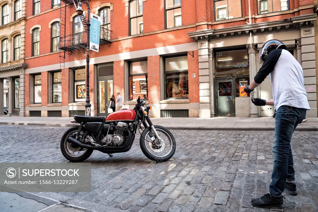 Soho, Manhattan, New York City, Man, 20-30, in Cycle Riding Helmet, stoping to photograph his Motor Cycle on his smart phone.