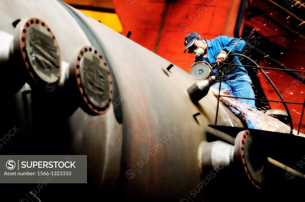 Metallurgical industry worker with protective mask grinding