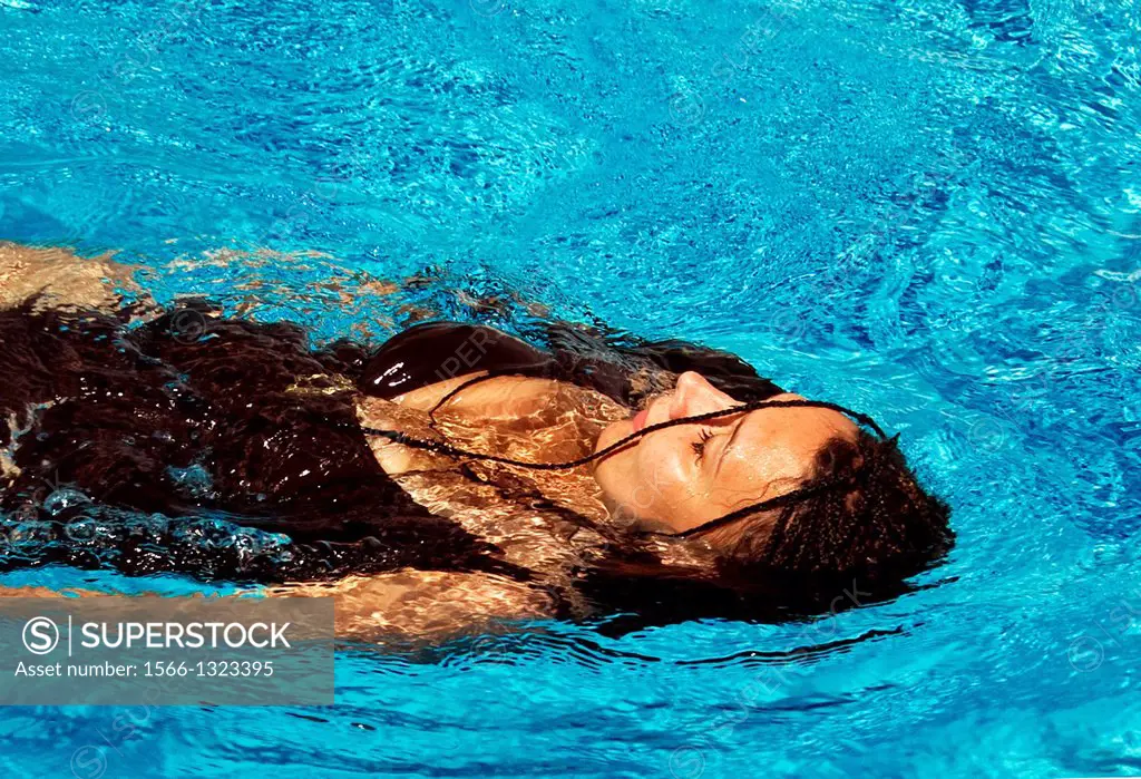 Woman resting in swimming pool, summertime