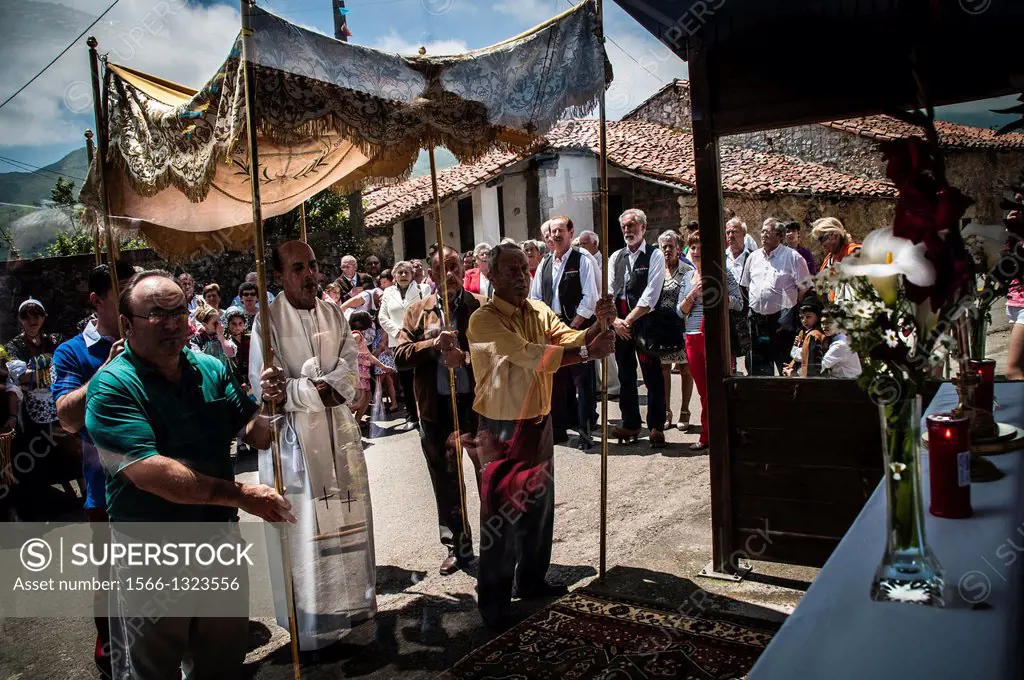 During the procession of Santa Eulalia de Carranzo, Llanes, the cure stop to pray in front of the makeshift altar at the bus stop. Asturias.