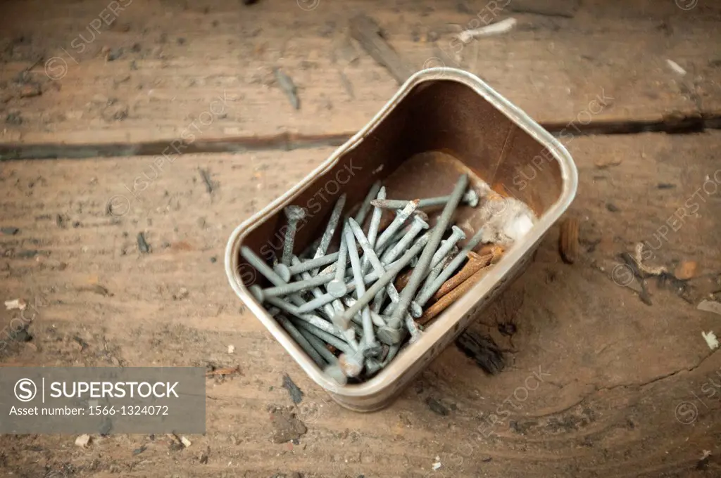 Box of nails and rusty nails at wood shop for ship restoration.