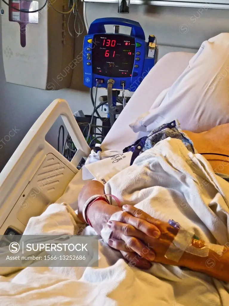 Hospital patient connected to blood pressure monitor.