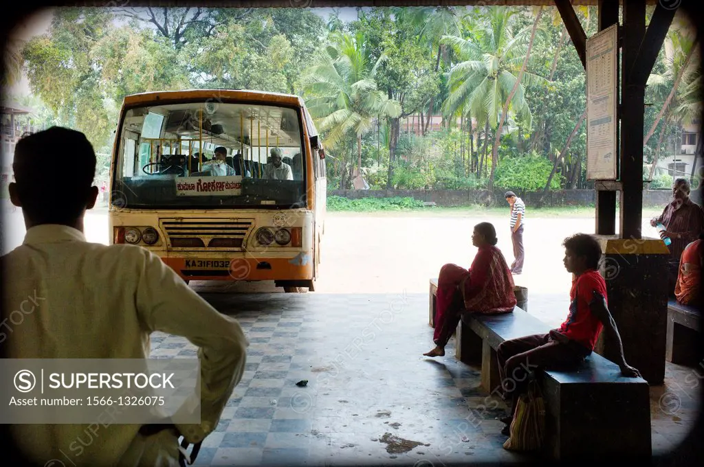 People waiting in a bus station on a beach near Goa, India, Asia